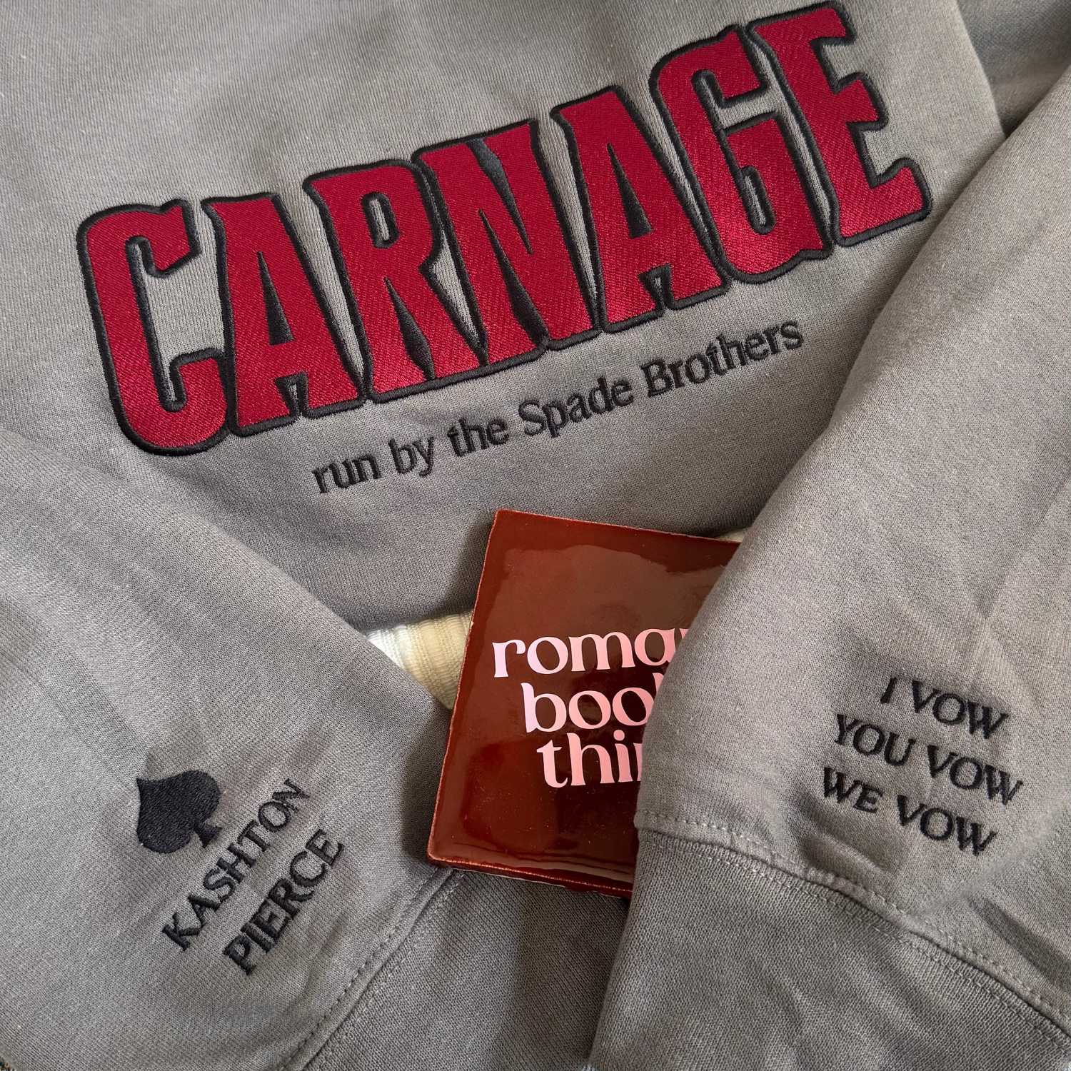 Carnage Spade Brothers embroidered sweatshirt flat lay inspired by the L.O.R.D.S series by Shantel Tessier Sleeve detail with Kashton Pierce